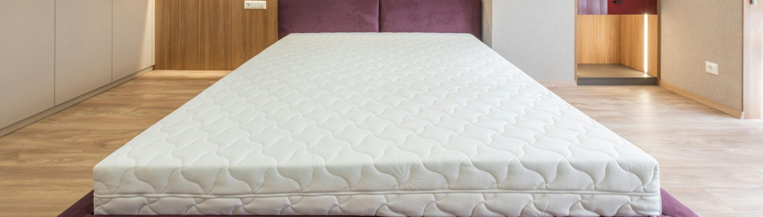 Modern interior design of empty bedroom with cozy king size bed without sheets and empty closets